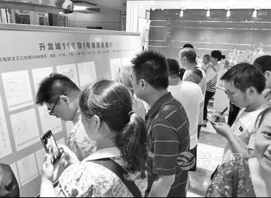 二七区公租房分配现场，许多人在房源展板前挑选房子