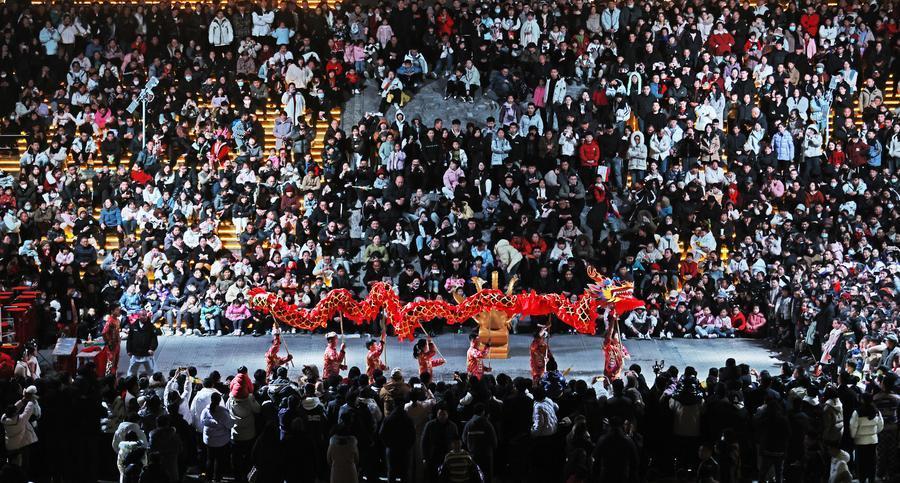 2024年2月12日，游客在山东省临沂市郯城县郯国古城景区观看舞龙表演。 新华社发（张春雷 摄）