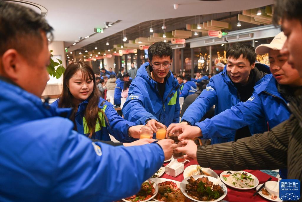 2025年1月22日，快递员和家属在“年夜饭”活动上碰杯。当日，200余名大部分来自外地的快递员及家属受邀参加一场“年夜饭”活动，提前在异乡感受春节团聚的温暖。 新华社记者 黄宗治 摄