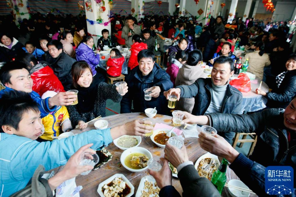 2011年2月2日，浙江诸暨一家公司准备了丰盛的年夜饭，招待800多名没有回家过年的员工及其家属，欢聚一堂共迎新年。新华社发(郭斌 摄)