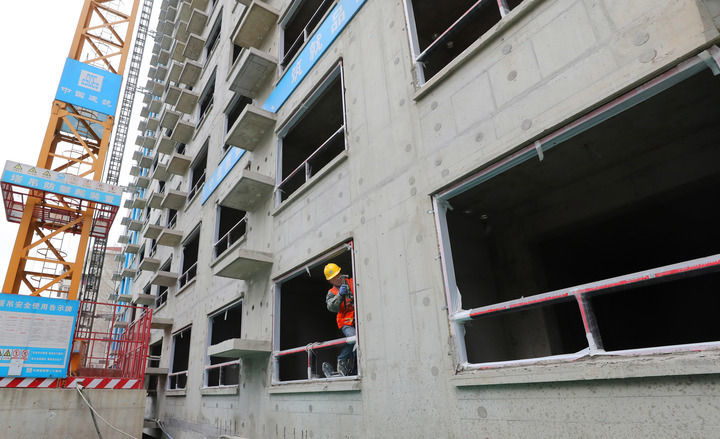 2024年3月15日，工人在上海市静安区谈家桥城市更新项目工地安装窗户框架。新华社记者 方喆 摄