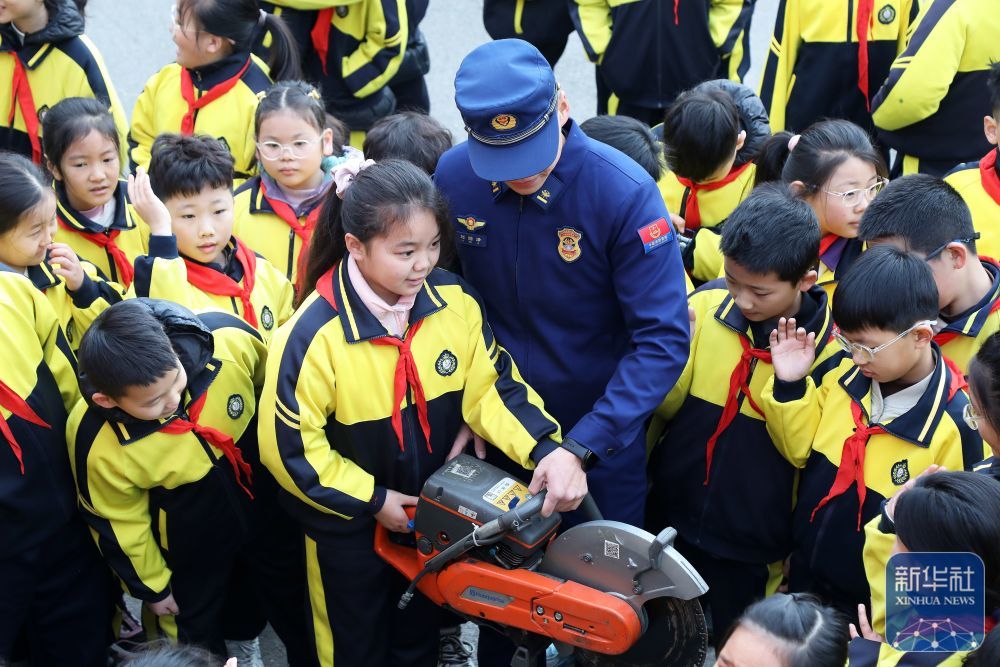 2月14日，在山东省枣庄市市中区东湖小学，消防员带领学生们近距离触摸消防器材。新华社发（王海楠摄）
