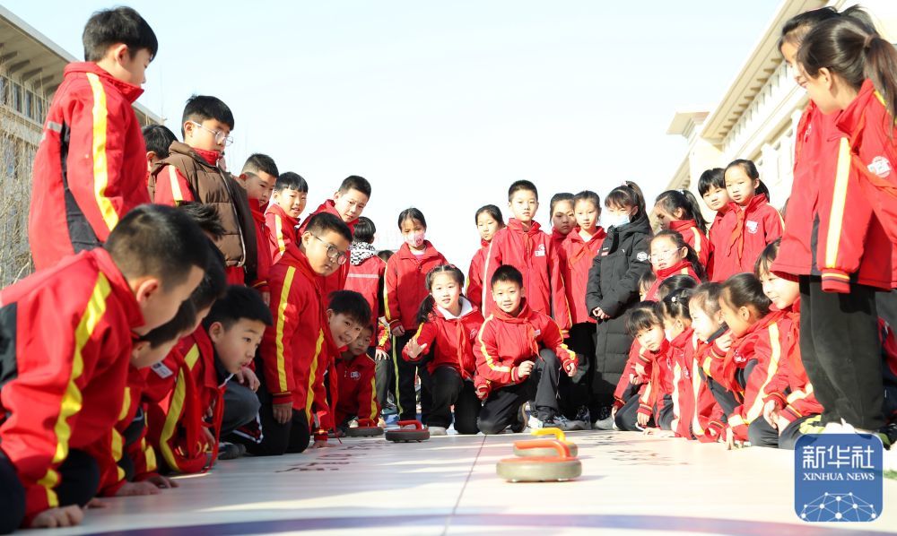 2月14日，河北省沧州市东光县第三实验小学的学生们在课间参加陆地冰壶活动。新华社发（周洋摄）