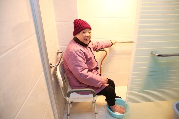 2024年2月1日，江苏省常州市钟楼区荷花池街道居民钱金秀老人在家中洗脚。卫生间的适老化改造方便了老人的居家生活。新华社发（陈暐摄）
