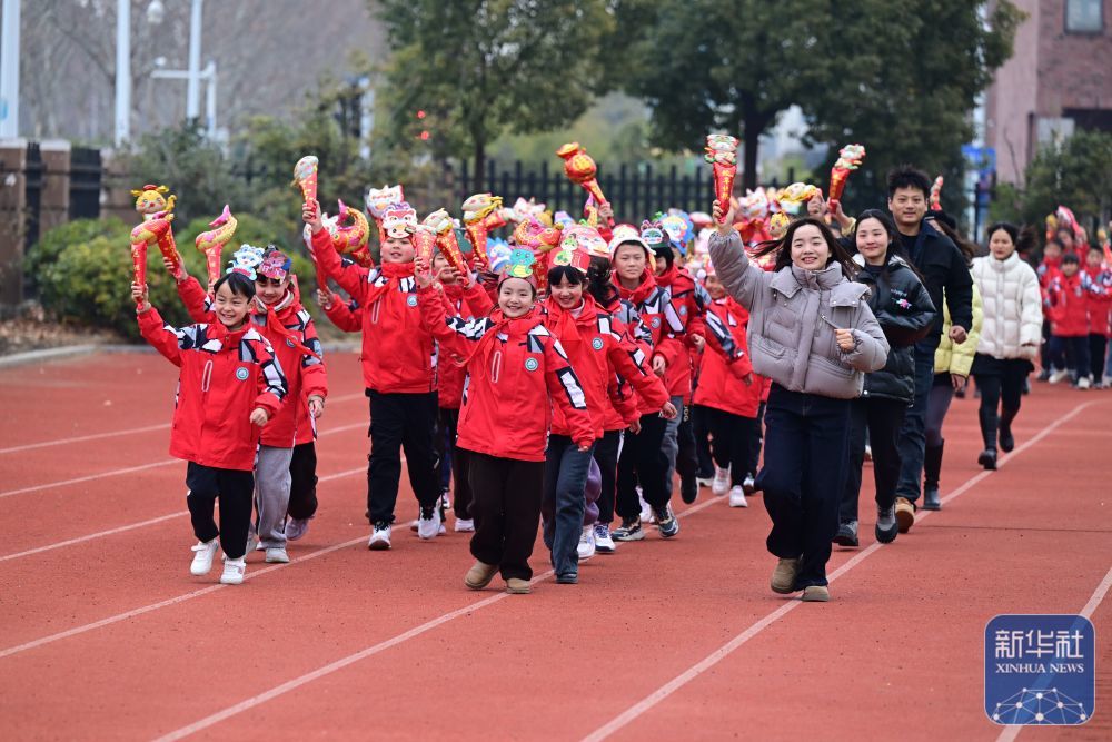 2月14日，合肥市园上园小学喻岗分校师生在开学典礼上进行“贪吃蛇”接力跑活动。新华社记者 周牧 摄